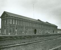 Vue en angle de la Gare ferroviaire Canadien Pacifique, qui montre les façades du devant et du côté.; Parks Canada Agency/Agence Parcs Canada, 1973.