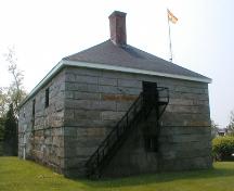 This side elevation includes a metal stairway leading to a door on the second level of the building.; PNB 2004