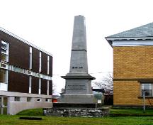 Vue de la façade et du côté est du monument Hamilton, montrant le monument dans son environnement, la bibliothèque au gauche et le palais de justice à la droite.; Restigouche Regional Museum, Dalhousie