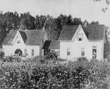 Image du côté sud de la maison Reid Stewart montrant le bâtiment d'origine (à la droite) et le premier ajout d'une zone de collecte laitière, une cuisine d'été et une zone d'entreposage.; Restigouche Regional Museum, Dalhousie