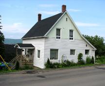 Vue vers le nord-est, montrant l'avant et le côté de la maison, ainsi que le toit à pignon fortement incliné qui change l'angle de la pente au dessus de l'appentis.; Restigouche Regional Museum, Dalhousie