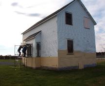 Exterior view of the Bay Roberts Railway Station showing men working on the facade.  They are painting to help protect the exterior until restoration can occur. Photo taken October 17, 2007.; HFNL/ Deborah O'Rielly 2007