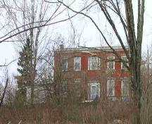 The front facade of the house; Norma Stewart