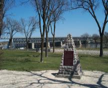 In background, the St. Andrews Caméré Curtain Bridge Dam National Historic Site of Canada, 2004.; Parks Canada Agency / Agence Parcs Canada, 2004.