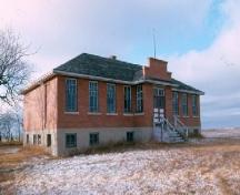 View of the school at the Pheasant Forks Heritage Site featuring the brick walls and massing, 1985.; Government of Saskatchewan, G. Pugh, 1985
