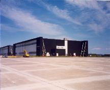 Vue du hangar 7, qui montre les grandes surfaces dégagées formées par les aires de trafic et les voies de circulation asphaltées, 1992.; Department of National Defence / Ministère de la Défense nationale, 1992.