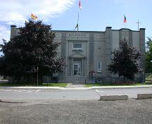 Cette image de la façade illustre la géométrie équilibrée et symétrique, ornée de pilastres à rainures et la frise dentelée, tous de style Art Déco.; PNB 2004