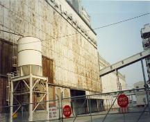Vue de l'extérieur de l'élévateur 5 B, qui montre son échelle, son design et les matériaux employés, qui rehaussent le caractère industriel et portuaire du secteur ouest du Vieux-Port, 1995.; Parks Canada Agency / Agence Parcs Canada, J. Hallé, 1995.