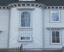 Cette photographie montre la fenêtre en baie arrondie très ornée caractérisée par une fenêtre à arc en plein cintre au-dessus des panneaux décoratives, 2006; City of Saint John