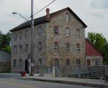 Corner view of the Old Stone Mill, showing its composition of five-bay façades with three-bay end elevations, 2004.; Parks Canada Agency / Agence Parcs Canada, 2004.