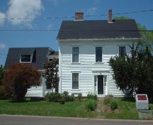 Vue de la façade sud montrant la partie principale de l'édifice avec la grange attachée à gauche et le monument de personnage historique national en avant.; Province of New Brunswick, Heritage Branch