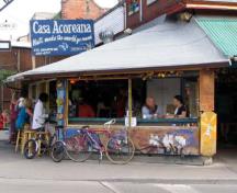 Photo d'un café au coin de la rue Baldwin et de l'avenue Augusta au lieu historique national du Canada du Kensington market, 2004.; Agence Parcs Canada / Parks Canada Agency, Michel Pelletier, 2004.