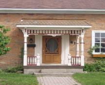 Featured is the porch with intricate wooden spindles and trim.; Chelsey Tyers, 2008.