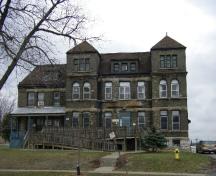 Of note is the stone horizontal coursing on the buff-brick facade.; Emily Elliot, 2007.