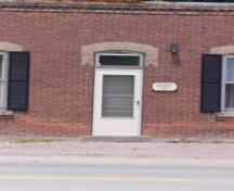 Of note are the brick voussoirs and transom above the doorway.; Kirsten Pries, 2008.