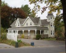 Of note is the cross gabled roof with varying pitches and the wrap-around porch.; Paul Dubniak, 2009.