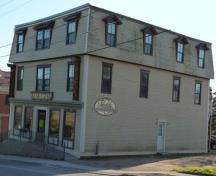 Cette image montre le coin nord-est de l'immeuble ayant abrité autrefois une quincaillerie, un magasin d'harnais et la pharmacie West's et qui aujourd'hui abrite la pharmacie Ford's.; Village of Hillsborough