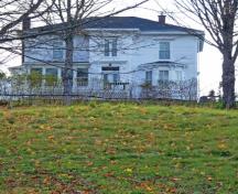 Cette image montre la maison imposante accentuée par la collection de dépendances bien entretenues qui la servent.; Village of Hillsborough