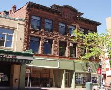 La maçonnerie en pierre d’origine de la façade avant de l’Empire Block existe encore aujourd’hui. Des locataires occupent les appartements du deuxième et du troisième étage, quelques entreprises commerciales occupent aussi cet édifice. ; Moncton Museum
