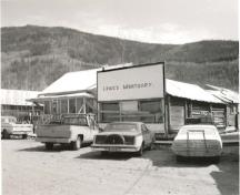 General view of Lowe's Mortuary, showing its false-front façade with painted lettering, 1987.; Agence Parcs Canada / Parks Canada Agency, 1987.