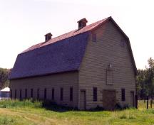 View of the exterior of the Barn, showing its wood sash windows, spaced evenly on the broad sides of the barn and symmetrically positioned on the ends, 1995.; Parks Canada Agency / Agence Parcs Canada, 1995.