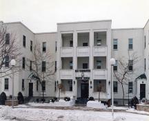 Façade du bâtiment 21, qui montre les balcons en surplomb au-dessus de l’entrée principale, 1994.; Department of National Defence / Ministère de la Défense nationale, 1994.