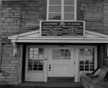 View of the main entrance to the St. Louis Barracks, showing the masonry work, including coursed rubble stone and brick, 1969.; Agence Parcs Canada / Parks Canada Agency, 1969.
