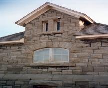 Side view of the Maintenance Building, showing the stone walls, built up in irregularly coursed rough-cut limestone, 1988.; Parks Canada Agency / Agence Parcs Canada, 1988.