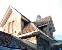 Detail view of the Maintenance Building, showing the hip and cross gable roof, 1988.; Parks Canada Agency / Agence Parcs Canada, 1988.