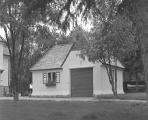 Vue de la façade générale du garage du directeur du parc, qui montre les pierres des champs à la base des murs extérieurs, 1988.; Parks Canada Agency / Agence Parcs Canada, Zd Gregr, 1988.