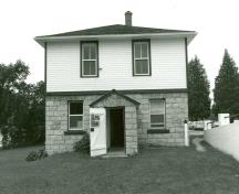 Vue de l'entrée principale de la résidence fortifiée du maître-éclusier de Lower Brewers, qui montre les façades symétriques caractérisées par la disposition régulière des fenêtres et des portes, 1989.; Department of Public Works / Ministère des Travaux publics, 1989.