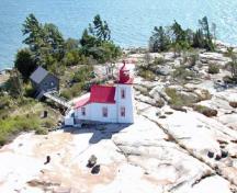Vue générale du phare d'alignement antérieur de Brébeuf Island, montrant sa position sur une surface rocheuse plane et nue.; Parks Canada Agency/ Agence Parcs Canada, Fisheries and Oceans Canada/ Pêches et Océans Canada