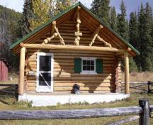 Vue de l'entrée principale du chalet des gardes du parc de Brazeau, qui montre sa volumétrie rectangulaire d’un étage et son toit à pignon en surplomb, moyennement incliné qui forme un porche à l’avant, 2005.; Parks Canada Agency / Agence Parcs Canada, 2005.