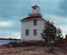 Façade du Phare, qui montre le petit phare carré, s’élevant directement au-dessus du centre de l’habitation.; Canadian Coast Guard / Garde côtière canadienne.