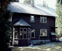Vue arrière de la résidence du directeur du parc, qui montre le bâtiment rectangulaire à deux étages, avec une baie d’un étage ajoutée à l’arrière, 1992.; Parks Canada Agency / Agence Parcs Canada, 1992.