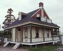 General view of Building 34, showing the large, wrap-around verandah, the wooden brackets and the turned wooden balusters of the verandah, circa 2004.; Parks Canada Agency / Agence Parcs Canada, circa / vers 2004.