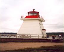 Vue de la façade laterale du phare côtier, qui montre le garde-corps métallique de la galerie et sa lanterne métallique octogonale, 2000.; Department of Fisheries and Oceans / Ministère des Pêches et des Océans, 2000.