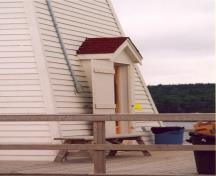 Vue en détail du phare côtier, qui montre l’entrée et son fronton en saillie, 2000.; Department of Fisheries and Oceans / Ministère des Pêches et des Océans, 2000.