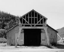 Façade of the Machine Shop, showing the distinctive overhead crane housing projecting from its front gable, 1988.; Parks Canada Agency / Agence Parcs Canada, 1988.