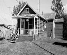 View of the Staff House, showing its distinctive log construction, 1988.; Parks Canada Agency / Agence Parcs Canada, 1988.