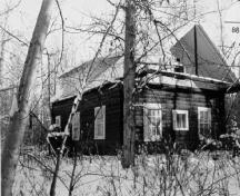 Corner view of the Troberg Residence, showing the domestic nature of its remote site, with its surrounding trees, 1988.; Agence Parcs Canada / Parks Canada Agency, 1988.