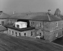 General view of Building 14, showing the solid masonry construction of regular coursed, smooth cut limestone, and the stone stringcourses, 1991.; Rhona Goodspeed, Parks Canada Agency / Agence Parcs Canada, 1991.