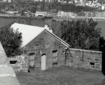 View of Building 32, showing the symmetrical façade with a door flanked by two windows, 1991.; Agence Parcs Canada / Parks Canada Agency, 1991.