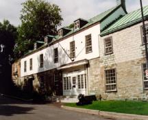 View of the main entrance of Building 2, showing the ground floor’s solid masonry construction and the stucco finish of the upper storey, 1993.; Parks Canada Agency / Agence Parcs Canada, Jocelyne Cossette, 1993.