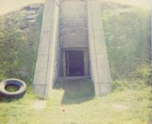 View of the entrance of RMC Building 30b, showing the small gable as an accent relating to the more visible architectural gestures of neighbouring structures, 1993.; Parks Canada Agency / Agence Parcs Canada, 1993.