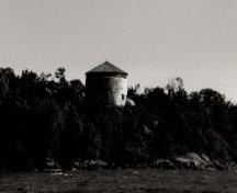 General view of the Cathcart Tower, showing the cylindrical tower with the shallow, conical snow roof that covers the parapet and gun platform, 1992.; Parks Canada Agency / Agence Parcs Canada, 1997.