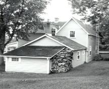 Rear view of the Lockmaster's House, showing the gabled roof and the chimney, 1989.; Parks Canada Agency / Agence Parcs Canada, Couture, 1989.