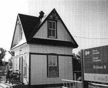 General view of Lockstation Cabin 8, showing the steep roof, the contrasting textures and colours adorning the wood siding, and the small pediments over the doors and windows, 1993.; Parks Canada Agency / Agence Parcs Canada, 1993.