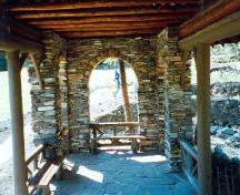 Vue de l'intérieur du pavillon Cambrien, où l'on peut apercevoir le sol dallé et les bancs de planches présentant des spécimens de nœuds, 1997.; Parks Canada Agency / Agence Parcs Canada, 1997.