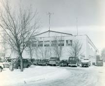 Corner view of the Queen Building, showing the horizontal bands of windows and relative absence of decoration, 1997.; Parks Canada Agency / Agence Parcs Canada, 1997.